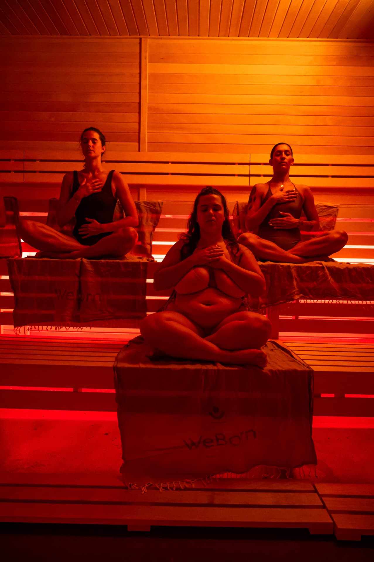 Drei Personen meditieren mit geschlossenen Augen in der WeBorn Sauna